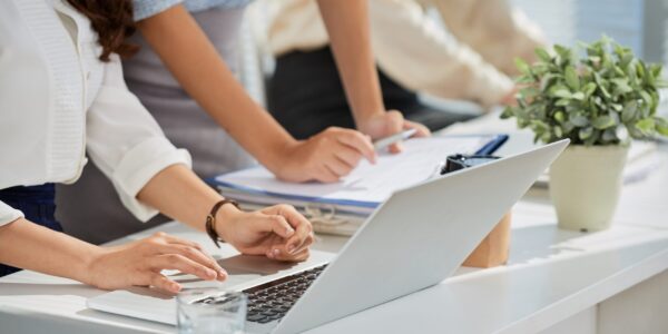 Cropped image of business ladies reading e-mails on laptop screen